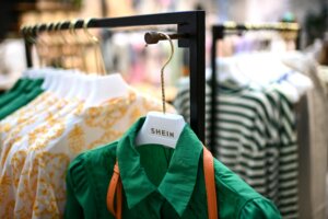 Clothes are displayed on hangers at a Chinese fashion brand Shein pop-up store in Paris on May 4, 2023. The Shein pop-up store is set to open for business from May 5 to 8. (Photo by Christophe ARCHAMBAULT / AFP)