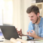 A man snarls at his laptop